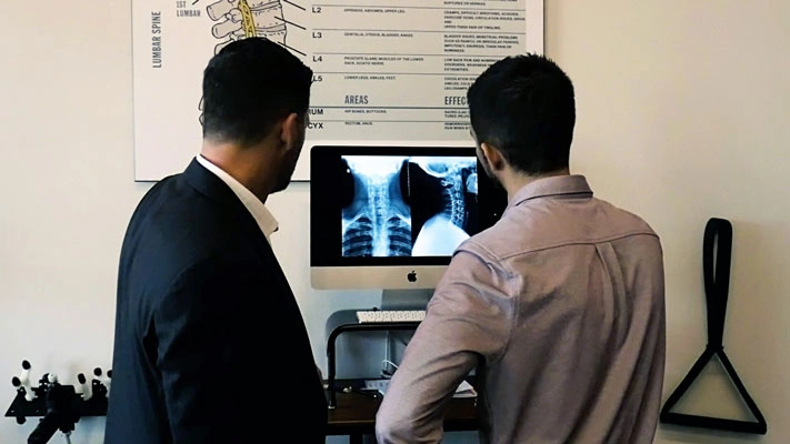 Chiropractor-Calgary-AB-DJ-LeDrew-Examining-XRay-With-New-Staff-Member Calgary SW chiropractor reviewing a patient's spinal X-ray at Full Potential Chiropractic