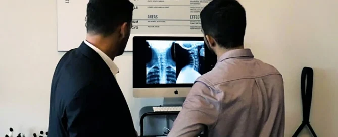 Calgary SW chiropractor reviewing a patient's spinal X-ray at Full Potential Chiropractic